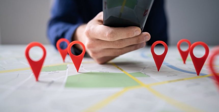 Person Using Map With Red Location Markers On Mobile Phone