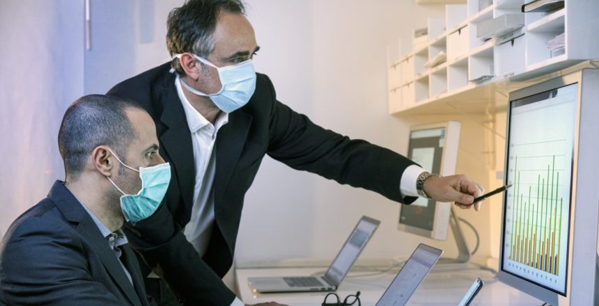 due manager con mascherina chirurgica lavorano al computer nel l